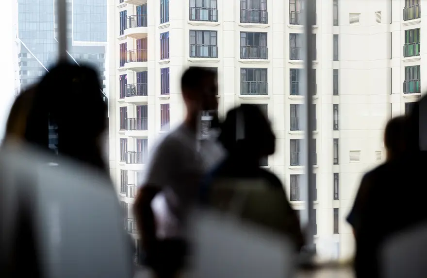 People silhouetted against a city view