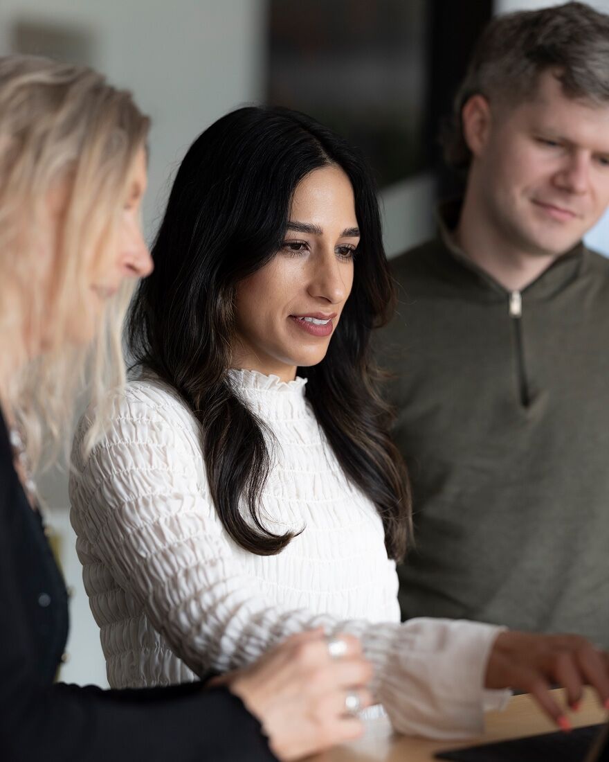 Three Ministry team members working together at a bench in the studio