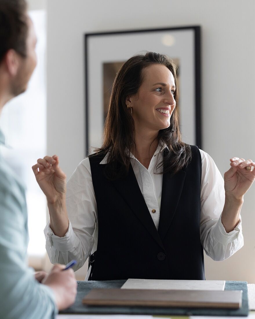 A Ministry designer smiling mid-conversation across the table