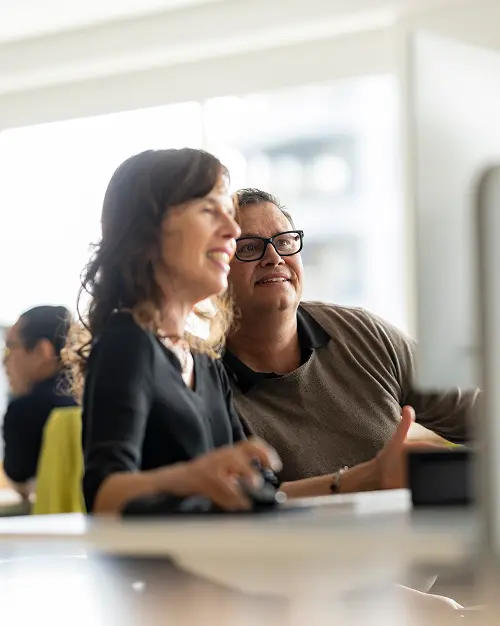 Two Ministry team members working together at a screen